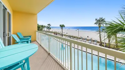a balcony with a table and chairs and the beach at Calypso 206W Low Floor West Tower No elevators needed in Panama City Beach
