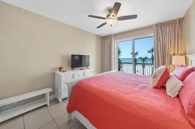 a bedroom with a red bed and a television at Calypso 208 East Direct Gulf Front Exceptional in Panama City Beach