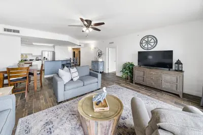 a living room with a couch and a tv at Calypso 209E 2nd floor Corner Unit 2 BR direct beach front in Panama City Beach
