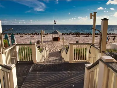 a wooden ramp leading to a beach with the ocean at Calypso 209E 2nd floor Corner Unit 2 BR direct beach front in Panama City Beach