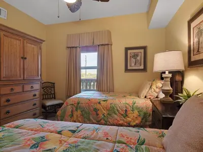 a bedroom with two beds and a dresser and a window at Calypso 209W Incredible Corner unit Best view in PCB in Panama City Beach