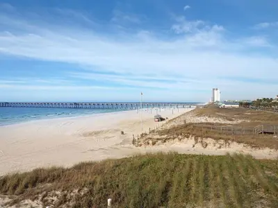 a view of a beach with a pier in the distance at Calypso 209W Incredible Corner unit Best view in PCB in Panama City Beach