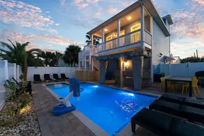 a house with a swimming pool in front of a house at Spring Break! Heated Pool, Walk 2 Beach, Sleeps 14 in Panama City Beach