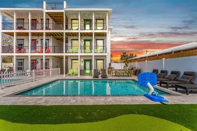 a pool with a slide in front of a house at Spring Break! Heated Pool, Walk 2 Beach, Sleeps 11 in Panama City Beach