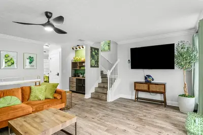 a living room with a couch and a flat screen tv at Spring Break! Heated Pool, Walk 2 Beach, Sleeps 11 in Panama City Beach