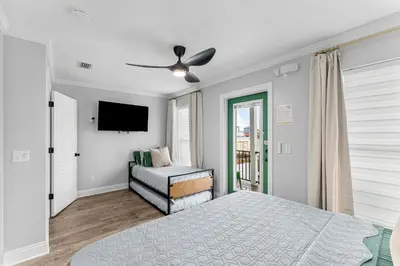 a white bedroom with a bed and a television at Spring Break! Heated Pool, Walk 2 Beach, Sleeps 11 in Panama City Beach