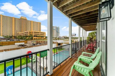 a balcony with two chairs and a swimming pool at Spring Break! Heated Pool, Walk 2 Beach, Sleeps 11 in Panama City Beach