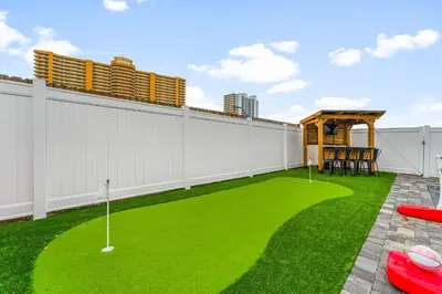 a backyard with a miniature golf course on the grass at Spring Break! Heated Pool, Walk 2 Beach, Sleeps 11 in Panama City Beach