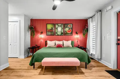 a bedroom with a green bed with a red wall at Spring Break! Heated Pool, Walk 2 Beach, Sleeps 11 in Panama City Beach
