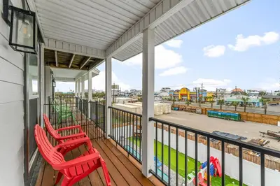 two red chairs on a balcony with a view of a harbor at Spring Break! Heated Pool, Walk 2 Beach, Sleeps 11 in Panama City Beach