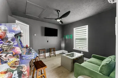 a living room with a green couch and a tv at Spring Break! 2 Homes, 2 Pools, Sleeps 22 in Panama City Beach