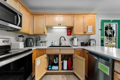 a kitchen with wooden cabinets and a sink at Spring Break! 2 Homes, 2 Pools, Sleeps 22 in Panama City Beach