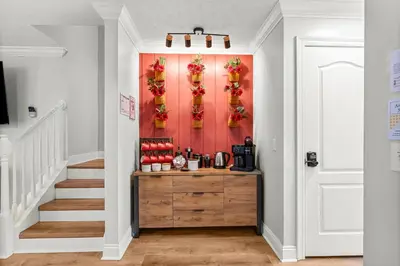 a hallway with a red wall with flowers on it at Spring Break! 2 Homes, 2 Pools, Sleeps 22 in Panama City Beach