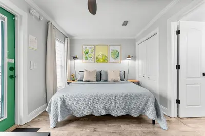 a bedroom with a bed and a green door at Spring Break! 2 Homes, 2 Pools, Sleeps 22 in Panama City Beach
