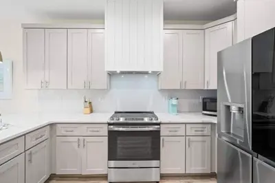 a kitchen with white cabinets and a stove top oven at Palm Paradise in Panama City Beach