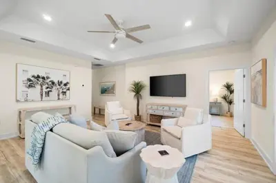a living room with white furniture and a flat screen tv at Palm Paradise in Panama City Beach