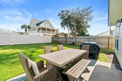 a patio with a table and chairs and a fence at Palm Paradise in Panama City Beach