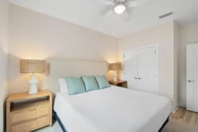 a bedroom with a white bed with blue pillows at Palm Paradise in Panama City Beach