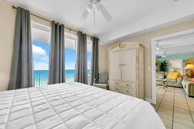 a bedroom with a large bed with a view of the ocean at Twin Palms 702 in Panama City Beach