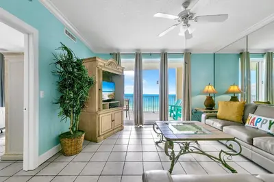 a living room with a couch and a tv at Twin Palms 702 in Panama City Beach