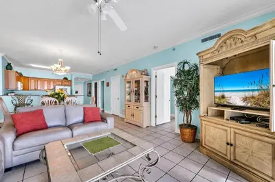 a living room with a couch and a flat screen tv at Twin Palms 702 in Panama City Beach