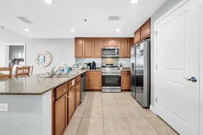 a kitchen with wooden cabinets and stainless steel appliances at Sterling Breeze 205 in Panama City Beach