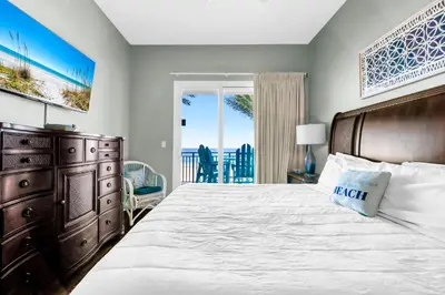 a bedroom with a large bed and a balcony at Sterling Breeze 205 in Panama City Beach