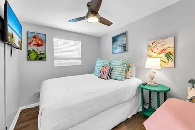 a bedroom with a bed and a ceiling fan at A Wave We Go in Panama City Beach