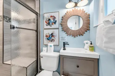 a bathroom with a toilet and a sink and a mirror at A Wave We Go in Panama City Beach