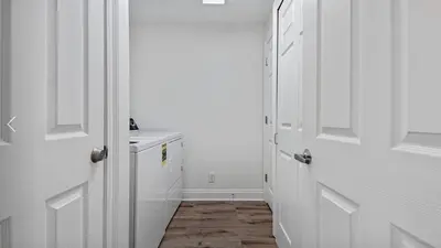 a white hallway with white doors and a sink at Calypso 302 West Direct Beach Front Awesome! in Panama City Beach