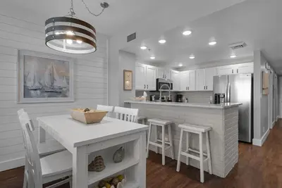 a kitchen and dining room with a table and chairs at Calypso 302 West Direct Beach Front Awesome! in Panama City Beach