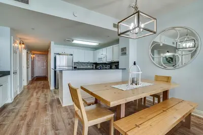 a kitchen and dining room with a wooden table and chairs at 408E Calypso Elegant beach front Beach Svc Included in Panama City Beach