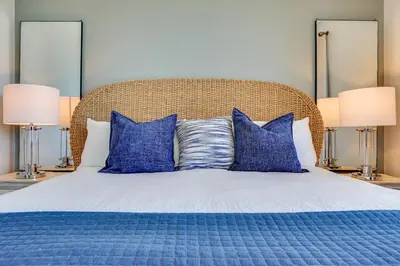 a blue bed with blue pillows and two lamps at Calypso 909 West Tower GULF FRONT 3BR 3BA Views Forever in Panama City Beach