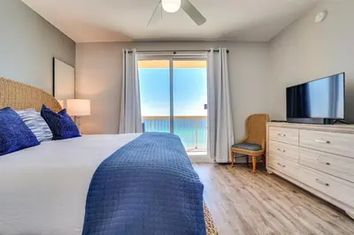 a bedroom with a bed and a tv and a window at Calypso 909 West Tower GULF FRONT 3BR 3BA Views Forever in Panama City Beach