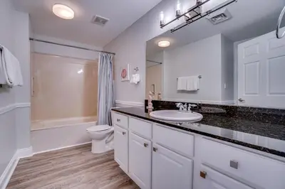 a white bathroom with a sink and a toilet at 1104 West 3 Bedrooms including 2 King Bedrooms and Custom Room in Panama City Beach