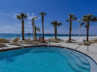 a swimming pool with palm trees and the beach at 1202 East Calypso Gulf Front 3Bedroom 2 Bath in Panama City Beach