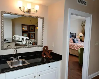 a bathroom with a sink and a mirror and a bedroom at 1202 East Calypso Gulf Front 3Bedroom 2 Bath in Panama City Beach
