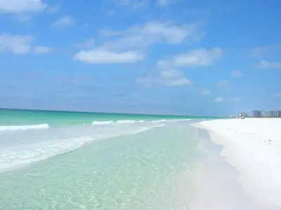 a white beach with the ocean and buildings in the background at 1202 East Calypso Gulf Front 3Bedroom 2 Bath in Panama City Beach