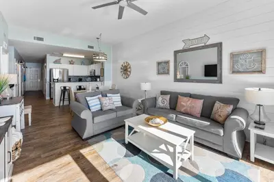 a living room with a couch and a table at Calypso 2308 West Penthouse Views Totally Remodeled in Panama City Beach