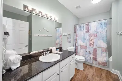 a bathroom with a sink and a toilet and a mirror at Calypso 2308 West Penthouse Views Totally Remodeled in Panama City Beach
