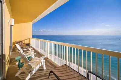 a balcony with two chairs and the ocean at Calypso 2308 West Penthouse Views Totally Remodeled in Panama City Beach