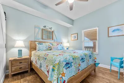 a bedroom with a bed and a ceiling fan at Calypso 2308 West Penthouse Views Totally Remodeled in Panama City Beach