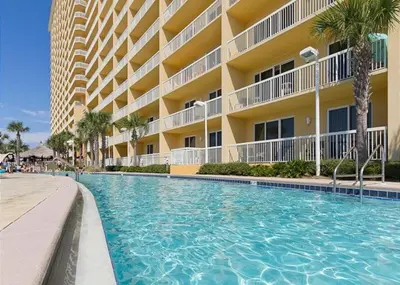 a swimming pool in front of a building at Calypso 2306W Penthouse VIP Parking and 2 sets of beach chairs in Panama City Beach