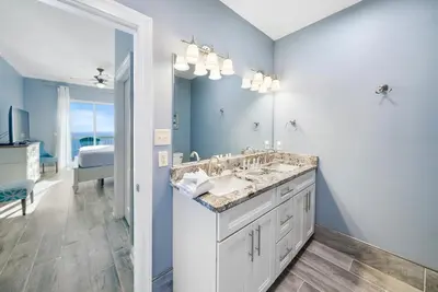 a bathroom with a sink and a large mirror at Calypso 2306W Penthouse VIP Parking and 2 sets of beach chairs in Panama City Beach