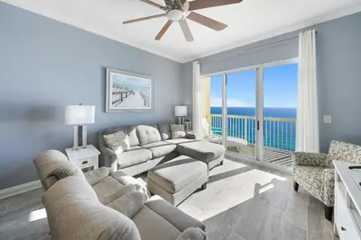 a living room with a couch and a table at Calypso 2306W Penthouse VIP Parking and 2 sets of beach chairs in Panama City Beach