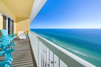 a balcony with blue chairs and the ocean at Calypso 2306W Penthouse VIP Parking and 2 sets of beach chairs in Panama City Beach