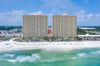 an aerial view of a beach with two tall buildings at Calypso 2306W Penthouse VIP Parking and 2 sets of beach chairs in Panama City Beach