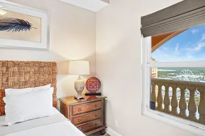 a bedroom with a bed and a window at Calypso 2306E Penthouse Condo 3BR 2BA Best Views Anywhere in Panama City Beach