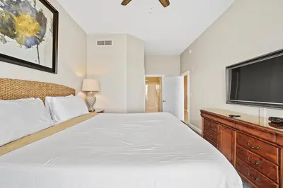 a bedroom with a large bed and a flat screen tv at Calypso 2306E Penthouse Condo 3BR 2BA Best Views Anywhere in Panama City Beach