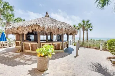 a hut with a straw roof on the beach at Calypso 1206 West Direct Gulf Front Custom Walk In Shower in Panama City Beach